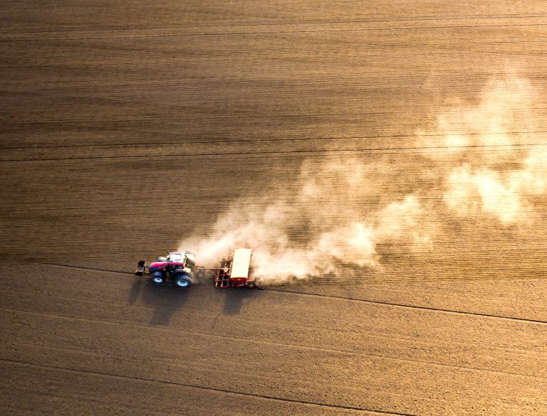 Tractor harvesting agricultural field