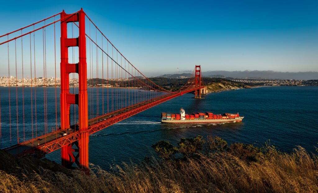 A cargo ship next to the Golden Gate bridge